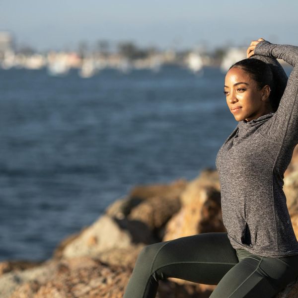 Person stretching outdoors at sunrise, feeling light and energetic.